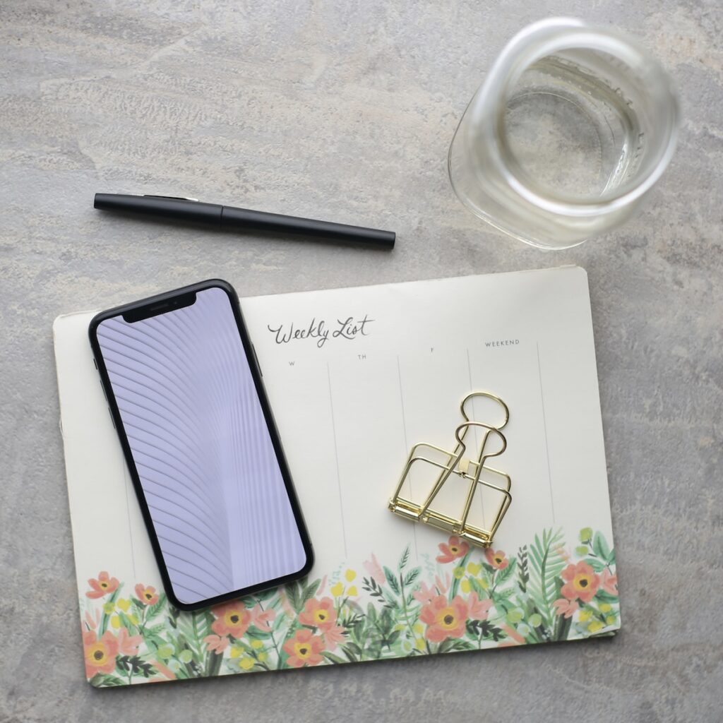 black pen, flowered notebook, water glass